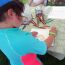 child-drawing-at-frogs-are-green-tent-city-of-water-day-hoboken thumbnail