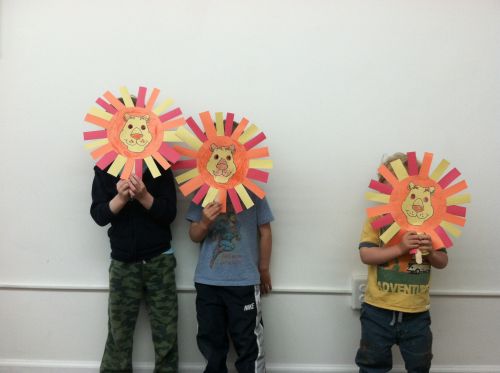 Boys create lion masks from colored paper in Peaceful Frogs class in Hoboken with Susan Newman