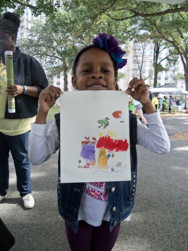 Little girl holds up her frog art drawing at WPLIVE