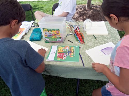 Children busy drawing with crayons, colored pencils and markers.